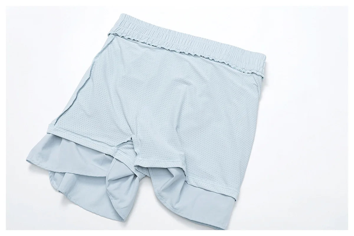 Light blue athletic shorts with inner lining on white background