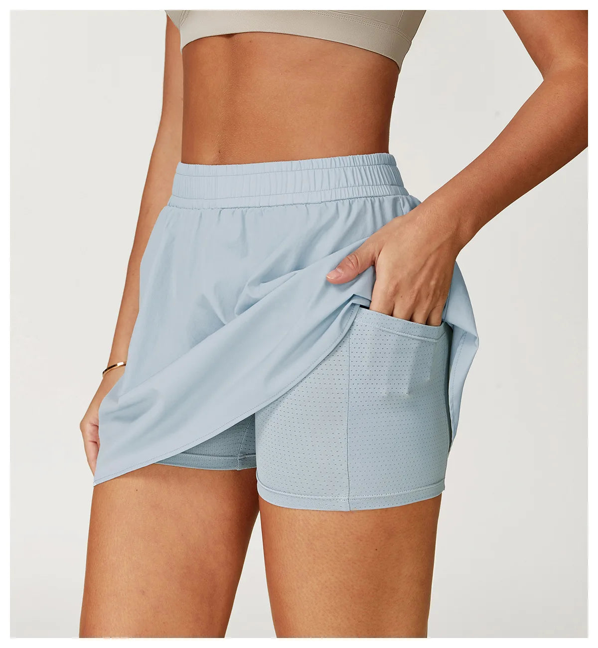 Woman wearing light blue 2-in-1 running shorts with built-in pocket and perforated inner layer