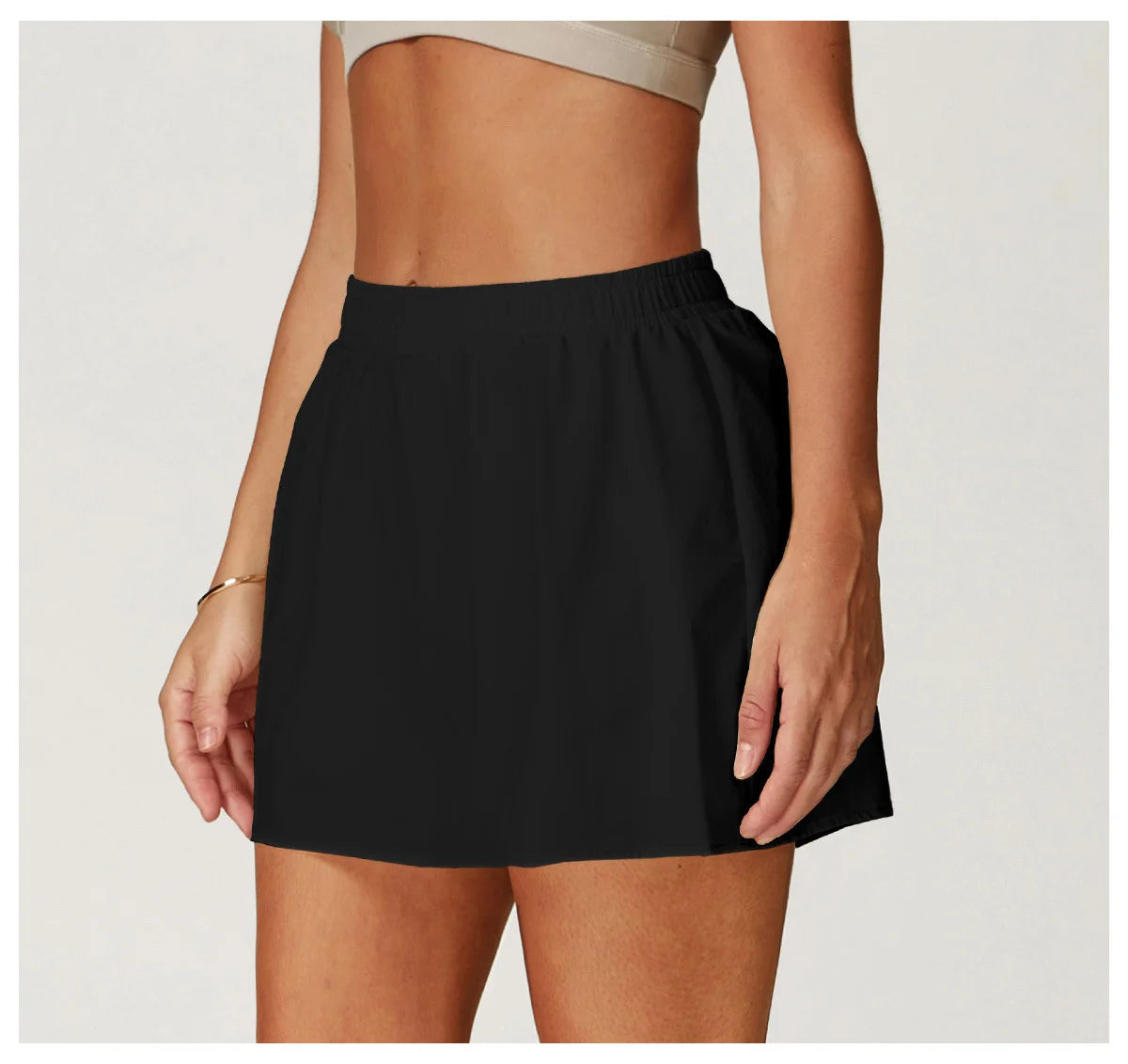 Woman wearing black athletic skirt with elastic waistband, activewear fashion