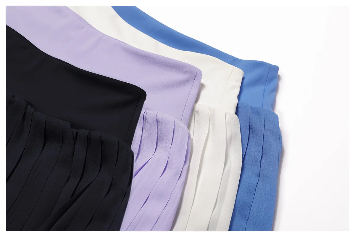 Pleated skirts in black, lilac, white, and blue chiffon fabric, neatly layered flat