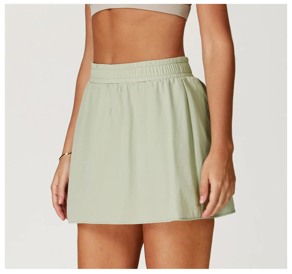 Light green high-waisted tennis skirt on woman, athletic casual wear