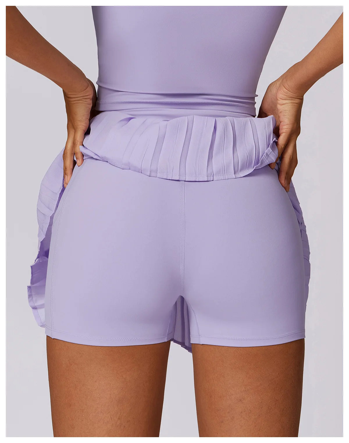 Back view of a woman wearing lilac ruffle skirted athletic shorts