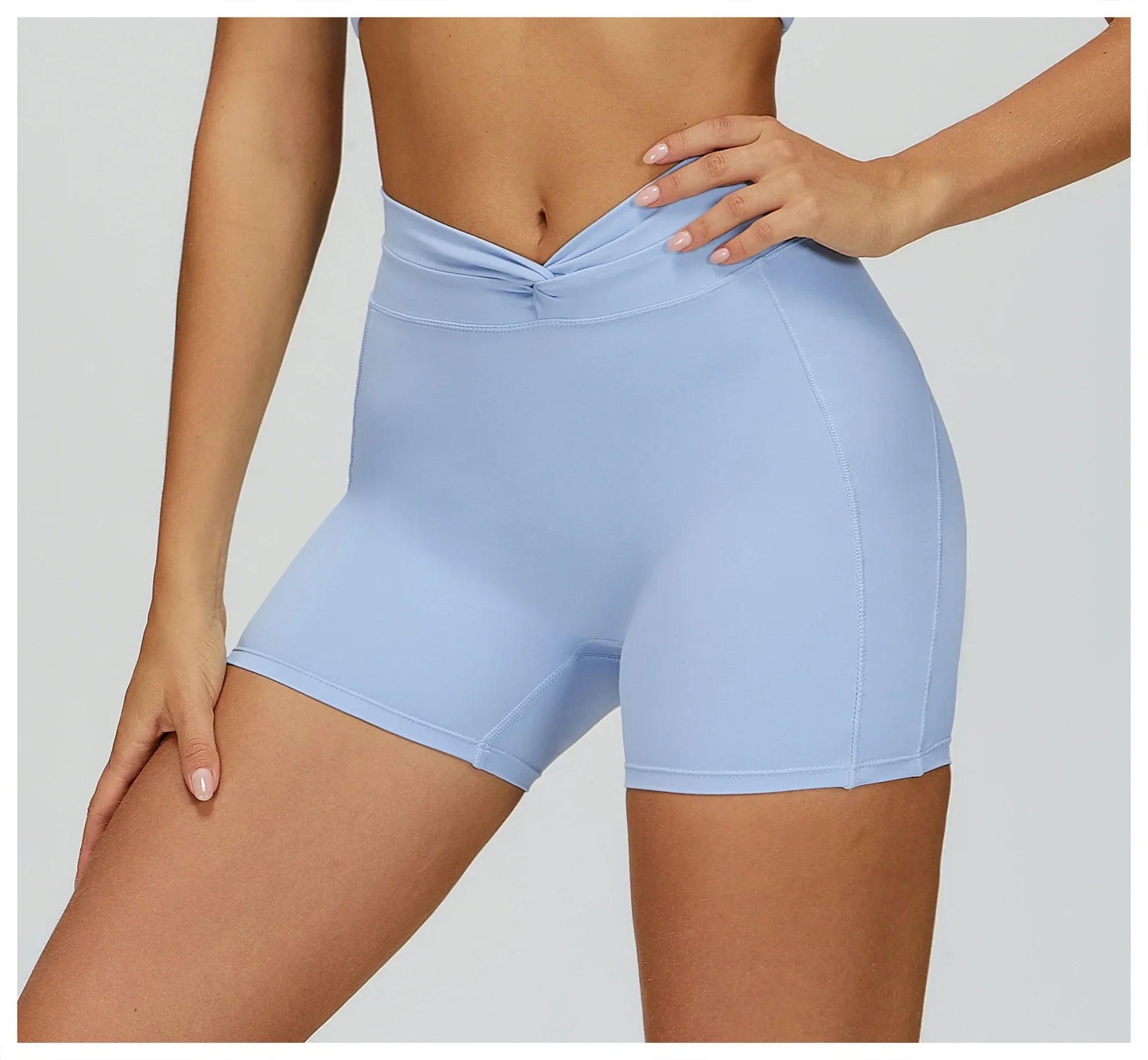 Woman wearing light blue high-waisted yoga shorts with V-shaped waistband