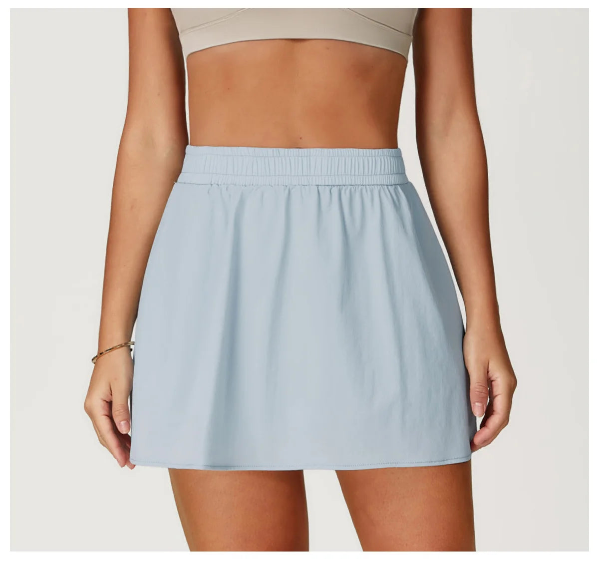 Woman wearing light blue athletic mini skirt with elastic waistband